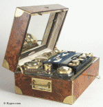 A fine Paris  NCESSAIRE DE VOYAGE  tightly packed with  tools and accessories for personal grooming.
The burr elm box is edged with brass  and has inset brass carrying handles.  The gilded silver toped cut crystal bottles and jars have the Paris silver mark for 1818-1838. The tools are a delight of mother of pearl and steel.  