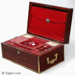 SB454: Mahogany and brass bound sewing box circa 1820
 This is a most unusual early sewing box, both strong and robust. The high quality of the structure suggests that it was made to withstand travel as well as sit in elegant drawing rooms. The mahogany is edged in squared brass all around and bears flat-folding side handles. The original interior is lined in red textured leather. The tray is in keeping with the exterior and is structured for strength. The envelope is most unusual and opens with a silver catch. Some bending on bottom brass suggesting that the box did travel! Working Bramah lock and key.  