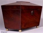 TC121: A flame mahogany tea caddy of tapered pyramid shape standing on brass ball feet with two lidded compartments and a central place for sugar bowl circa 1820. 