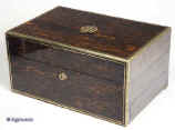 JB308: Antique box veneered in strongly figured  coromandel, with brass edging, central  inlaid ornate initials. working Bramah lock and key. The box is  high quality,  which continues into the interior. It is lined in velvet,  and  embossed leather. It has a lift-out tray and sprung drawer elaborately fitted for jewelry.   Circa 1840. Enlarge Picture