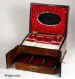  JB303: A figured walnut table cabinet with double doors to the front opening to reveal a drawer fitted for jewelry The box/cabinet also has  a compartmentalized lift out tray with supplementary lids covered in red satin.  There is an oval mirror on the inside of the lid framed with ruched red satin. Circa 1890. Enlarge Picture