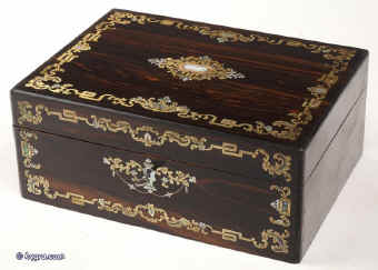  SB120: A fully fitted sewing box veneered in thick striated coromandel  and inlaid in brass and shell, both mother of pearl and abalone. Inside there is the original fitted liftout tray  lined with silk and velvet, with a set (6)  of carved and turned mother of pearl daisy pattern spools designed for the new thread which now came on wooden reels.  The tray also has supplementary lids with carved mother of pearl pulls.   The box also has period  sewing tools including penknife button hook, and tweezers, and bodkin with mother of pearl handles. The steel scissors is designed for cutting button holes.  There is a document wallet in the lid. Circa  1870. Enlarge Picture