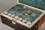 SB121: A rare fully fitted tortoiseshell sewing box of rectangular form and shaped top by Thos' Lund of Cornhill, having ivory facings, silvered hinges and lock, mother of pearl escutcheon and name plate engraved "Mrs. Brown". Inside there is a liftout tray with green and blue silk coverings  and supplementary lids  containing  turned and carved mother of pearl spools (8) and other sewing tools. The inside the lid is covered in ruched blue silk framed with a smooth silk border and contains  a document wallet in the lid. Circa 1820. Enlarge Picture