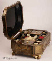 SB474: A very fine Chinese export lacquer sewing box of complex curved octagonal form, with fine decoration of oriental scenes framed within cartouches standing on gilded bat feet. The background is filled with diaper designs of stylized flora. Inside there is a lift out tray with supplementary lids and   sewing tools  made of turned and carved ivory.   The box has gilded side handles and hinges. Circa  1835. Enlarge Picture