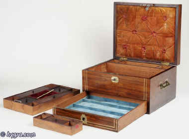  Antique rosewood box having inset brass carrying handles, and   inlayed brass lines to the top and front, and a separately secured drawer fitted for jewelry. Inside the box there is a liftout tray  with supplementary lids and smaller boxes.  There is a document wallet in the lid which retains its original velvet covering.  Circa 1820 Enlarge Picture