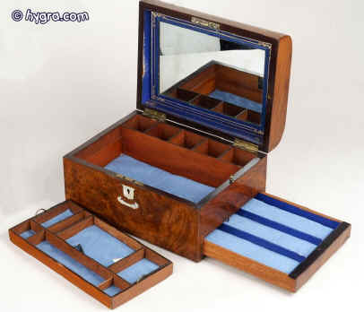 JB 227  A richly figured burr walnut dome top box with liftout tray and  sprung drawer fitted for jewelry. There is a liftout gold embossed leather framed mirror in the lid with a document wallet behind Circa 1860 Enlarge Picture