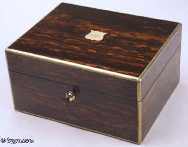 JB310:A  brass edged coromandel jewelry box, by H. Trussell of Brighton the hinged lid opening to reveal a velvet and gold embossed lined interior and two lift-out trays. The box has a working Bramah lock and key. Circa 1840.  Enlarge Picture
