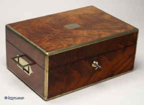 JB316: Brass edged flame mahogany fully fitted dressing box with inset brass handles and Bramah lock opening to a leather covered lift out tray with cut glass bottles with hallmarked silver tops (1827-9) a document wallet in the lid. Circa 1830. Enlarge Picture