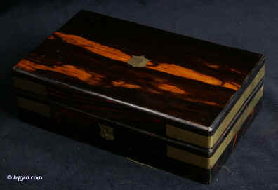 JB411: Box veneered is strongly figured coromandel and bound with continuous brass straps foe strength and dramatic contrast. Circa 1850. Enlarge Picture