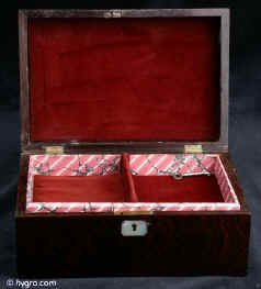 JB416: A box veneered in figured rosewood with mother of pearl central plaque and escutcheon. Added lift out tray. Small repairs to bottom corners, hardly visible. Working lock and key. Circa 1830. Enlarge Picture