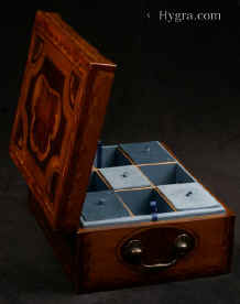 JB431: A rare and striking box made by a gifted craftsman who had a truly artistic instinct for the materials at his disposal. Patterns are created by different woods, which mutually enhance and compliment the varied qualities of the timbers, resulting in an object the beauty of which is wholly created by projecting organic natural growth. The faint straight grain of the background veneer is an unobtrusive background which allows the dramatic centre to make a bold and striking statement: the force and beauty of a living plant. The box has a replacement tray with supplementary lids. Circa 1790. Enlarge Picture