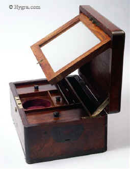 JB439: Brass edged and inlaid solid rosewood box suitable for jewelry having inset brass carrying handles, working Bramah lock  with key  and a separately locked drawer. There is an adjustable mirror in the lid. The main section of the box has several sections some with supplementary lids. Circa 1825. Enlarge Picture