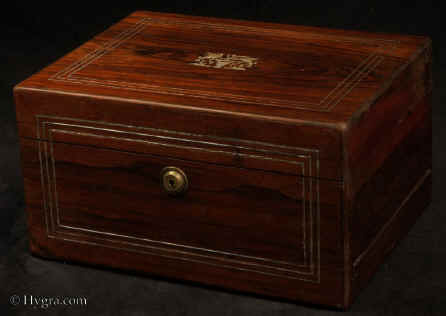 JB512: A figured rosewood box of oblong form having inlays of white metal and mother of pearl inlay depicting two birds drinking from a cup. The box also has  a Bramah lock, a side drawer fitted for jewelry  and a liftout tray. Circa 1830. Enlarge Picture