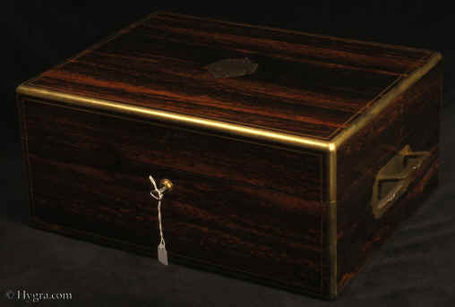 JB523:Antique box veneered in strongly figured  coromandel,   by Hunt and Roskell, London. The box  has  brass edging,  central inlaid and engraved brass plaque, countersunk brass carrying handles, and a  working  Bramah lock with  key. The compartmentalized interior of the box is  also of very high quality.  It is lined in velvet and embossed leather and has a lift-out tray.  There is a document wallet in the lid. Circa 1870. Enlarge Picture