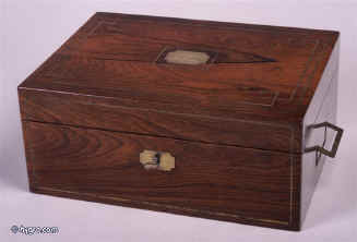 JB 185: Early 19th century Rosewood veneered  box with brass countersunk handles and subtle  accents. This box typifies the understated quality of the period. The interior is lined in velvet and leather in a color combination which is again typical of the time. The bottles have silver plated tops. It bears the Edwards label. Enlarge Picture