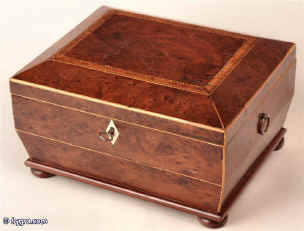  A shaped Regency box veneered with burr yew, edged with boxwood, the top crossbanded with kingwood,  standing on turned bun feet having two Victorian velvet and leather lift out trays fitted for jewelry Circa 1810 Enlarge Picture