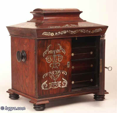 A  dramatic William IV rosewood  compendium table cabinet of lofty architectural form  having turned rosewood feet and handles. It is inlaid with mother of pearl and opens both to the top and the and the front  and has two drawers one with a liftout tray  fitted for jewelry; the upper part is  also fitted for jewelry, circa 1835 Enlarge Picture
