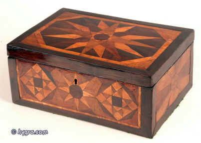 Hygra JB205 Antique box veneered all over with parquetry executed in exotic native and imported hardwoods including rosewood, maple, satinwood, oak, ash and fruitwoods and depicting geometric motifs, the inside relined with hand made marbled paper  and having a liftout velvet covered replacement tray circa 1800. Enlarge Picture