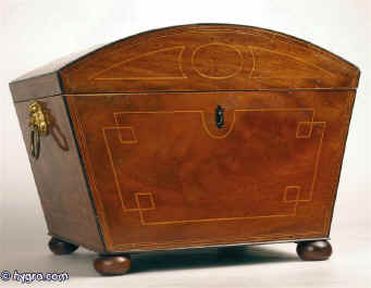 A Regency box with tapering sides  and domed top veneered  with beautifully figured mahogany  inlaid with boxwood in a restrained classical pattern, and framed with an  elaborate purfling  of boxwood and ebony with a crossbanding  of kingwood,  and edged with ebony, having gilded brass lion drop side handles  and standing on turned mahogany bun feet.  Inside the box has been been relined with hand made marbled paper and grey velvet. It has a replacement liftout tray which makes it suitable for jewelry and sewing circa 1810.  Enlarge Picture