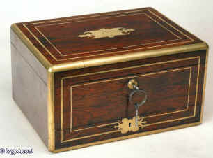 JB214: Antique top quality rosewood box edged and inlaid with brass, the top having an elaborate cartouche engraved with a armorial crest of a wingless Sphinx with a rose dexter,   the box having a leather covered liftout tray, working Bramah lock with key, and separately locked drawer fitted for jewelry, and embossed leather document wallet in the lid. Circa 1820. Enlarge Picture