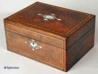 Jb220: a early Victorian box veneered with highly figured burr walnut framed  to the top and front with tulip wood cross banding and further elaborate parquetry bandings in maple, wenge, and ebony, having rounded tulipwood edges. Inside the box retains its original lift out tray with supplementary lids. The quilting in the top and the silk coverings to the supplementary lids are  original but otherwise the box has been relined. There is a decorative inlay of mother of pearl and abalone in the center of the top and as escutcheon. circa 1850 Enlarge Picture