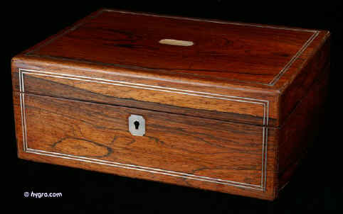 SB402: A Victorian figured  rosewood box  by Mechi of London. with rounded edges inlaid with white metal and having a mother of pearl escutcheon retaining its original liftout compartmentalized tray with supplementary lids  and having a  document wallet to the lid. circa 1840    Enlarge Picture