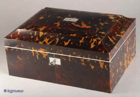 SB121:A rare fully fitted tortoiseshell sewing box of rectangular form and shaped top by Thos' Lund of Cornhill, having ivory facings, silvered hinges and lock, mother of pearl escutcheon and name plate engraved "Mrs. Brown". Inside there is a liftout tray with green and blue silk coverings  and supplementary lids  containing  turned and carved mother of pearl spools (8) and other sewing tools. The inside the lid is covered in ruched blue silk framed with a smooth silk border and contains  a document wallet in the lid. Circa 1820. Enlarge Picture