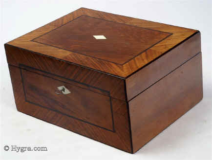 SB460: Walnut veneered box strikingly framed circa 1880. A box veneered in walnut and framed in figured walnut cut so as to emphasise the slanting stripes. It is further accented with separating black lines. The two tone interior is original and hardly shows any signs of wear. Working lock and key.
  Enlarge Picture