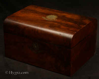 SB481: Burr walnut veneered box of rounded form, circa 1870. A box veneered in particularly well figured burr walnut. It is sparsely decorated with brass . The liftout  tray,  is all original and in particularly good condition; the  ruched back are original.  Working lock and key. Enlarge Picture