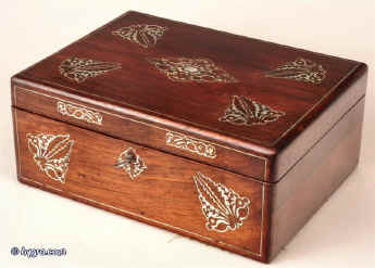 A rosewood veneered box, inlaid with mother of pearl in a stylized pattern, which forms a fine foliated design in reverse having a lift out tray, still covered with its original Tyrian purple silk  with divisions  for sewing. circa 1840 Enlarge Picture