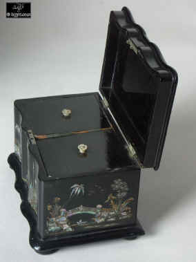 A serpentine fronted two compartment papier mch tea caddy decorated with chinoiserie painting on an iridescent pearl shell inlay.  Enlarge Picture