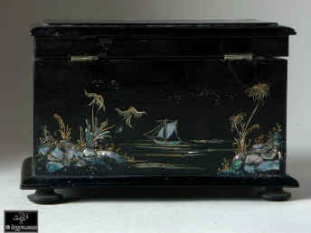 A serpentine fronted two compartment papier mch tea caddy decorated with chinoiserie painting on an iridescent pearl shell inlay. Enlarge Picture