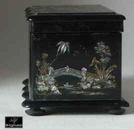 A serpentine fronted two compartment papier mch tea caddy decorated with chinoiserie painting on an iridescent pearl shell inlay. Enlarge Picture