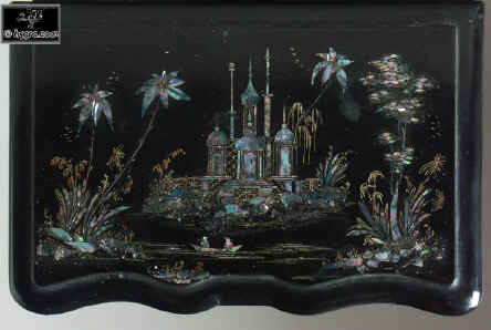 A serpentine fronted two compartment papier mch tea caddy decorated with chinoiserie painting on an iridescent pearl shell inlay. Enlarge Picture