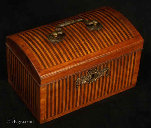 TC537:18th century tea caddy with domed top  the oak carcass veneered with a parquetry of rosewood and satinwood  in alternating stripes. framed by a crossbanding in kingwood.  The escutcheon is gilded bronze.  The inside is lined with lead foil. There is a single lid which would sit on the tea in the 18th century manner. Circa 1770. Enlarge Picture