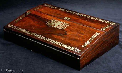 WB463: Writing slope in rosewood with brass inlay circa 1820. It is veneered in saw cut rosewood on mahogany and it is inlaid in brass.Inside the box has lidded compartments for pens, wax etc and two screw top distinctive inkwells. Enlarge Picture