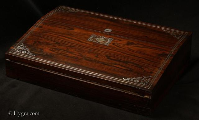 WB484: Writing slope in rosewood  with mother of pearl inlay circa 1835. This is a writing slope of good quality. The outside is veneered in saw cut rosewood inlaid with mother of pearl and white metal. The inlay is executed with precision.   Working lock and key. Enlarge Picture