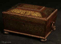 SB525: A rare early Regency  shaped  fully fitted brass inlaid figured rosewood sewing box retaining its carved and turned ivory spools and other sewing tools.  The form is typical of the early Regency: perfectly proportioned drawing its inspiration from ancient architectural structures. It has turned gadrooning drop ring  handles and feet. The box retains its original  fully fitted tray covered in yellow paper with gold embossed supplementary lids. Circa 1815. Enlarge Picture
