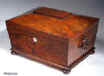SB126: Antique flame mahogany sewing box with tapered sides and pyramided top having turned mahogany drop handles and standing on turned bun feet. Inside the lid is lined with ruched blue silk framed with gold embossed leather. There is a document wallet behind. The box has a fitted liftout tray covered in the original blue paper and has silk covered supplementary covers circa 1815. Enlarge Picture