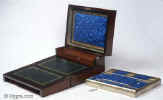 SB452: Rosewood veneered box with stylized brass and shell decoration circa 1870.
            This is an unusual box which combines a small writing box with a sewing tray. The engraved brass, mother-of-pearl and abalone decoration is fluid but
            stylized, combining the formality of neoclassicism with the naturalism of the Victorian era. The tray and the envelope compartment are original and hardly worn. The framing on the ruched surface is gold embossed. Working lock and key.  Enlarge Picture