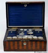 SB453: Satinwood and rosewood box veneered in stripes circa 1840. This is a fully fitted sewing box which oozes quiet elegance. The stripes emphasise the contrasting colours and varied figures of the two special timbers which cover the top and front. The box is edged in rounded rosewood giving the form a neat and defining line. The tray is edged in ebony, an unusual detail which contributes both to beauty and resistance to wear. The blue silk is original and so is the envelope under the lid. There is a set of seven hand made mother of pearl spools with metal shafts. This form of spool became fashionable in the 1830s when mercerised thread became increasingly more available. The tray also contains other mother of pearl and steel sewing tools. Working lock and key. Enlarge Picture