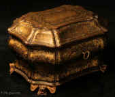 TC581: A curvaceous Chinese export lacquer tea chest with undulating sides decorated with two colours of gold depicting scenes of of Oriental life opening to a single compartment containing two lidded pewter tea canisters with supplementary inner lids, the whole chest standing on feet in the form of dragon heads. Circa 1840. Enlarge Picture