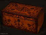 TC534:  Two compartment tea caddy,  the top and front decorated with marquetry in contrasting rosewood and birds eye maple  depicting stylized themes from nature.  Inside the caddy has two lidded compartments. Circa 1830 Enlarge Picture