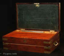 -Brass bound solid mahogany triple opening writing box   in the military  style with countersunk carrying handles  by Austen of Dublin: the fitted compartmentalized  interior has a document wallet,   secret drawers,  a replacement velvet writing surface , and working lock with key, Circa 1830 Enlarge Picture