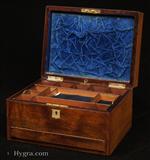 679JB: Antique Figured Rosewood box with lift-out compartmentalized tray and sprung drawer fitted for jewelry. There are mother of pearl escutcheons to the top and the front. There is a ruched velvet pad in the lid with mirror framed with gold embossed leather behind. It is released by pressing behind the lock catch. The sprung drawer is released by pressing on a button in the centre of the back facing. The lift-out tray is of mahogany construction with rosewood facings. New pads of velvet have been made to make the tray suitable for jewelry. There is further space beneath. Circa 1850.