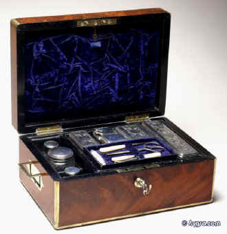 JB316: Brass edged flame mahogany fully fitted dressing box with inset brass handles and Bramah lock opening to a leather covered lift out tray with cut glass bottles with hallmarked silver tops (1827-9) a document wallet in the lid. Circa 1830. Enlarge Picture